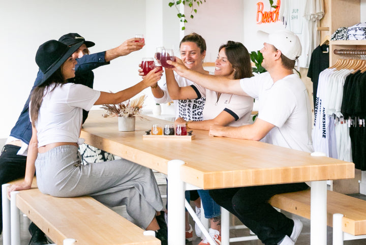 Friends cheers-ing glasses of JuneShine in the tasting room