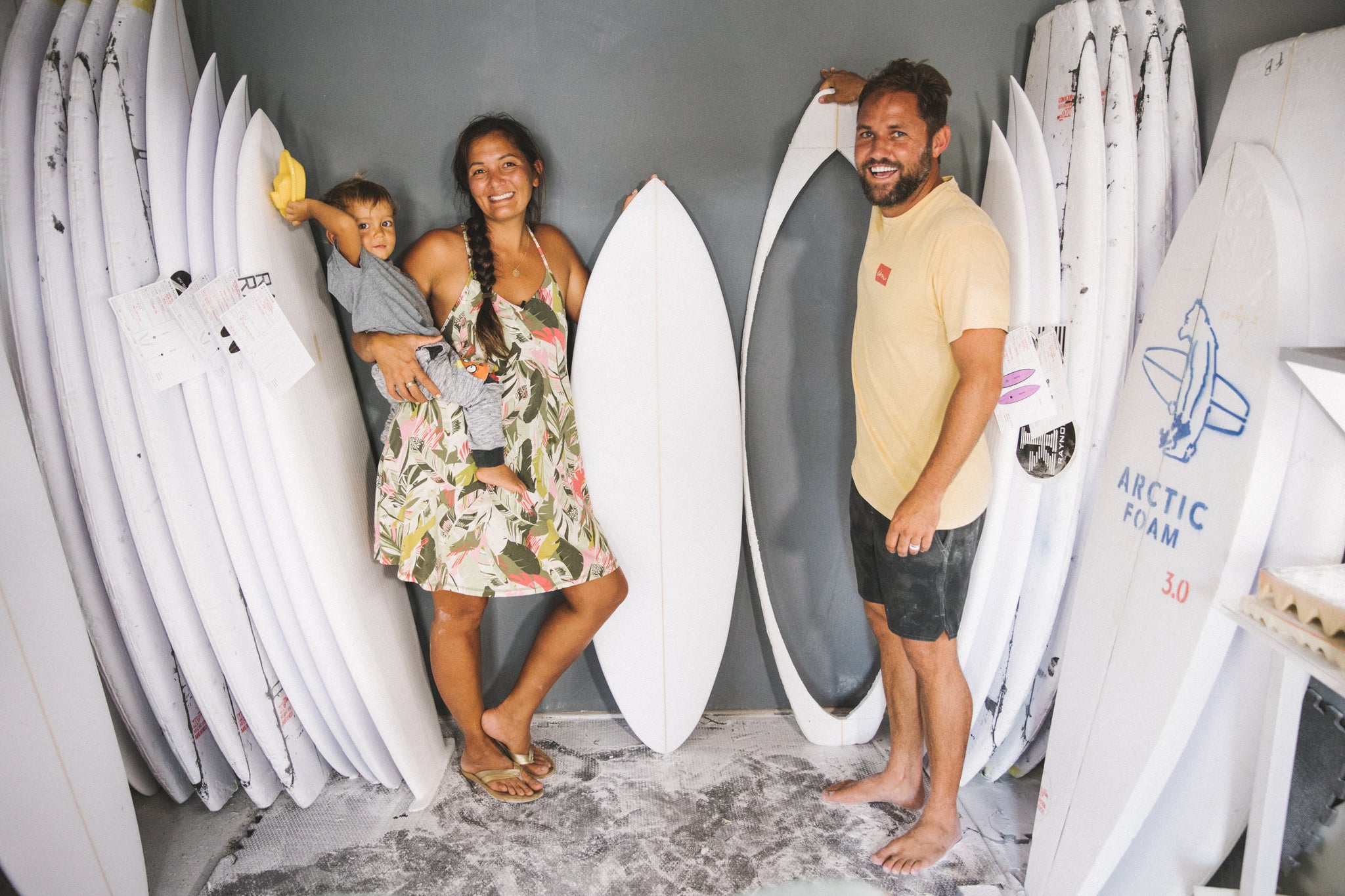 smiling people holding surfboards