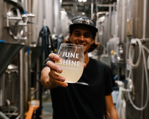 Person holding glass of Kombucha