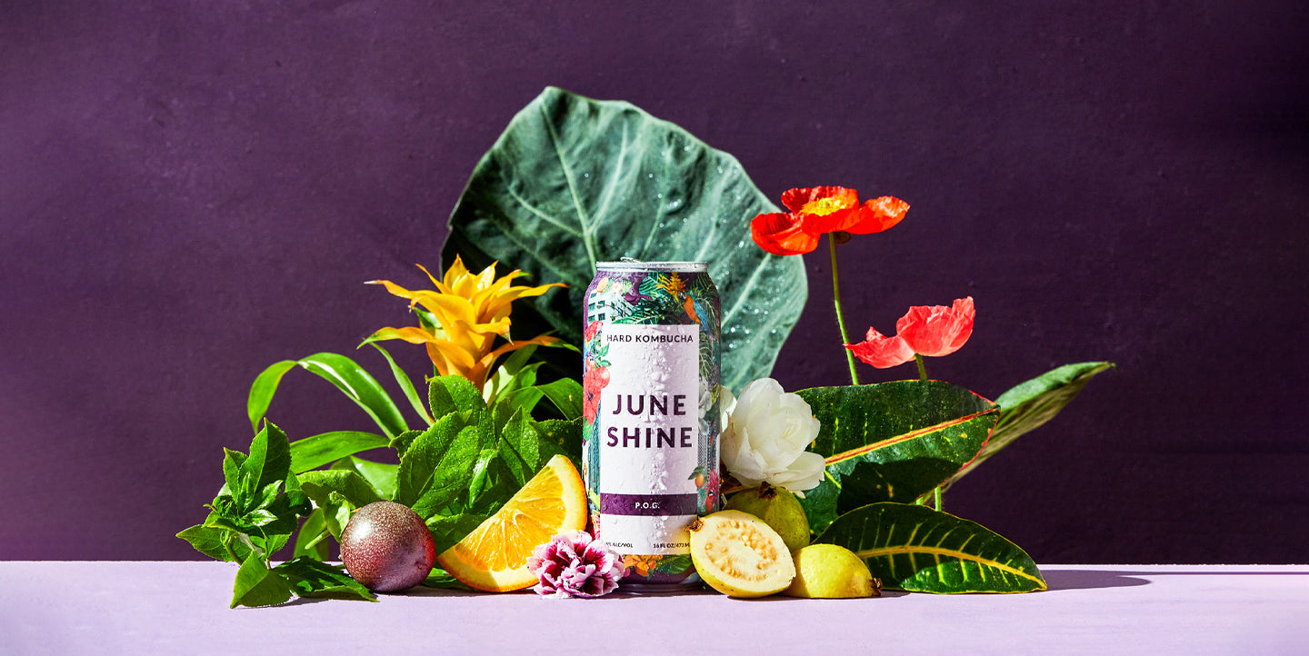 can of JuneShine POG in front of fruits and plants