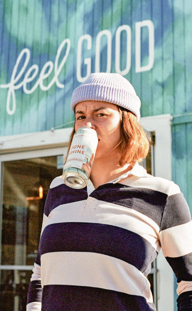 Nora Vasconcellos with a JuneShine can in her mouth