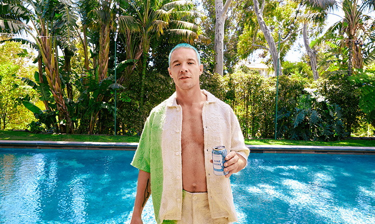 Diplo poolside with a can of his new flavor, Permanent Vacation